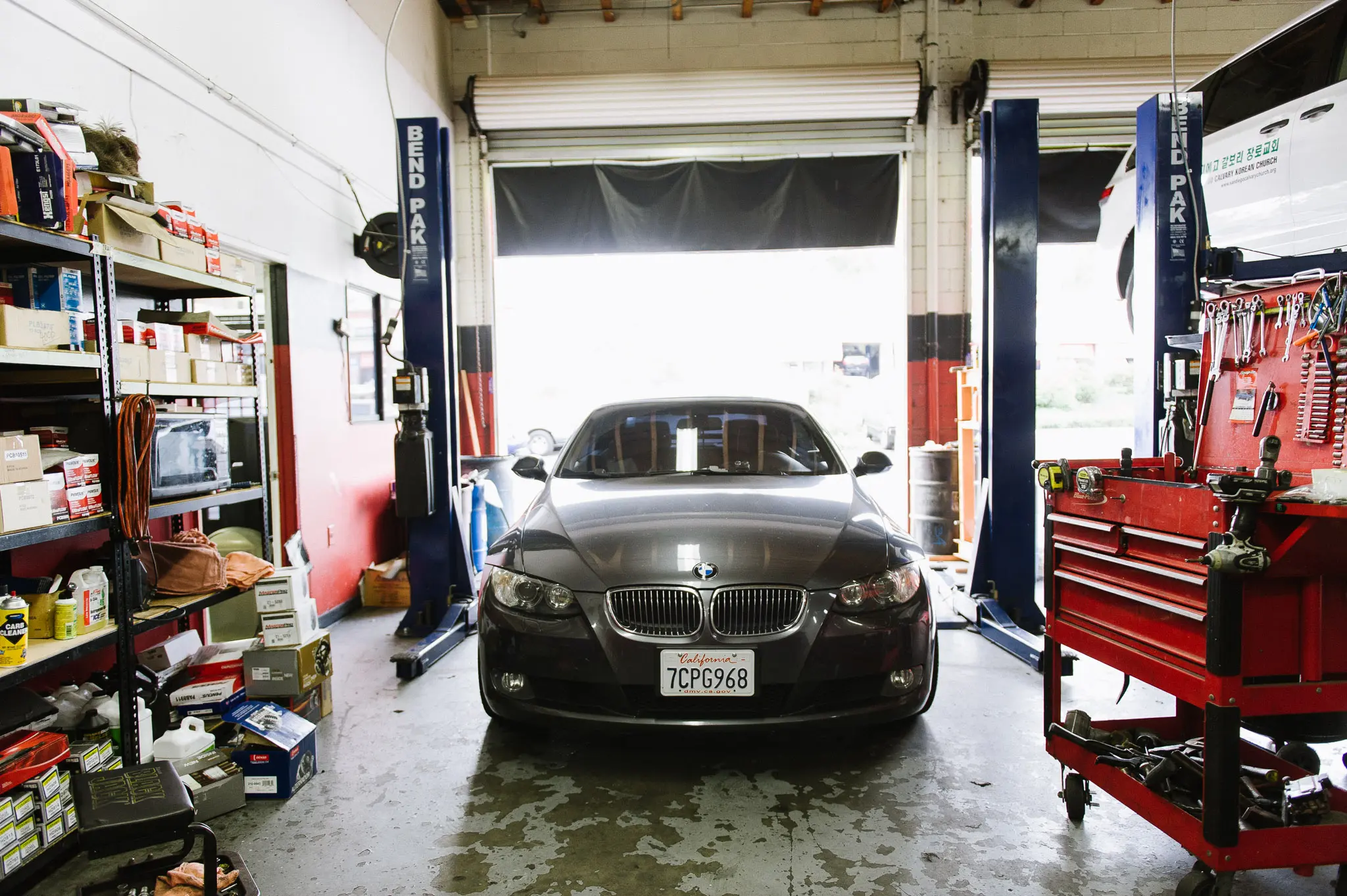 BMW on hydraulic lift inside SD Auto Medic's professional service bay at 3747 Convoy St, San Diego
